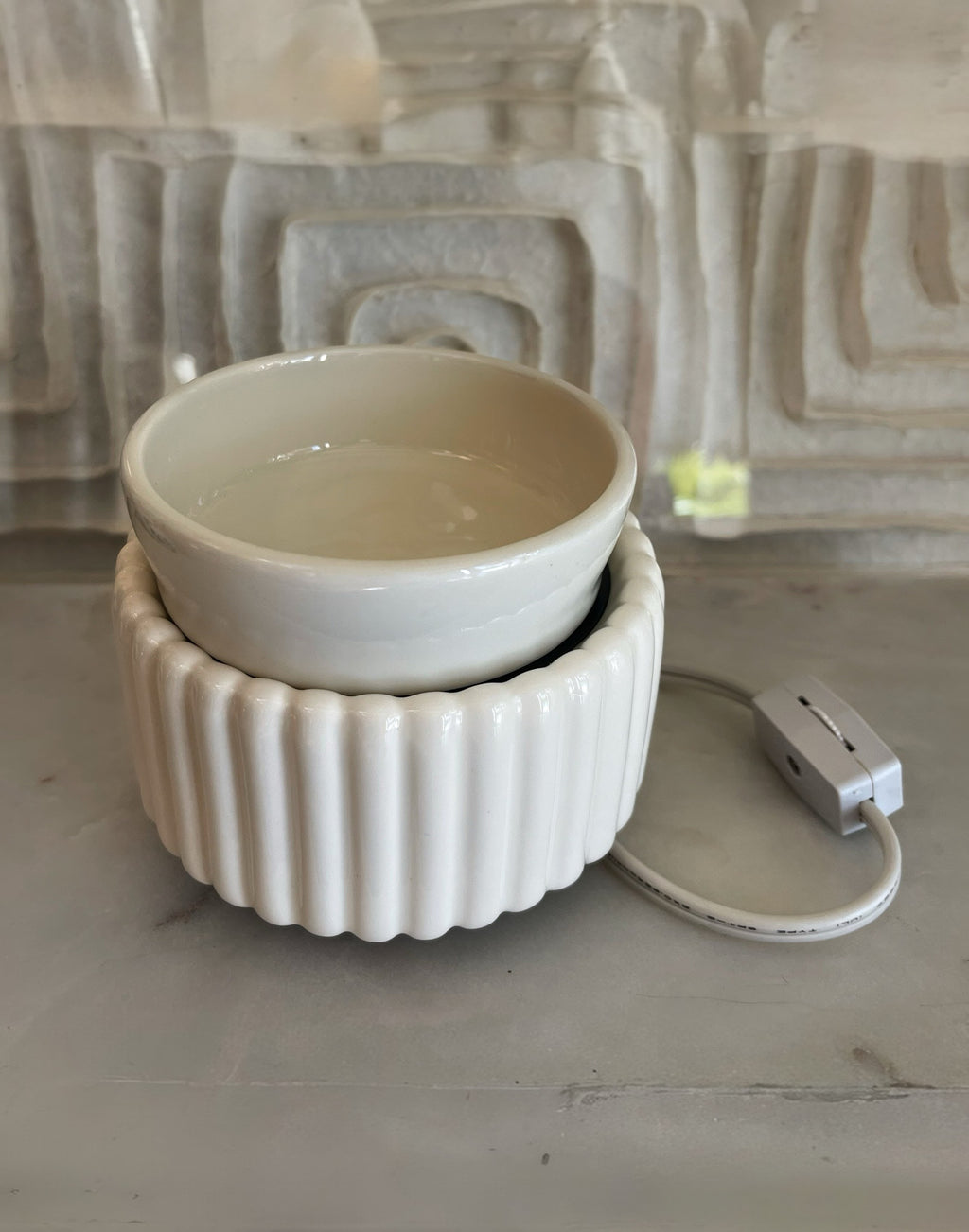 White ceramic bowl with a power cord on a textured surface