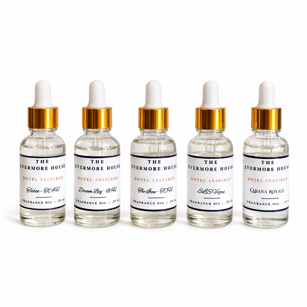 Five bottles of 'The Evermore House' fragrance oils with dropper caps on a white background.